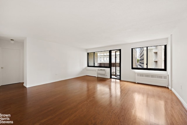 unfurnished living room featuring wood-type flooring and radiator