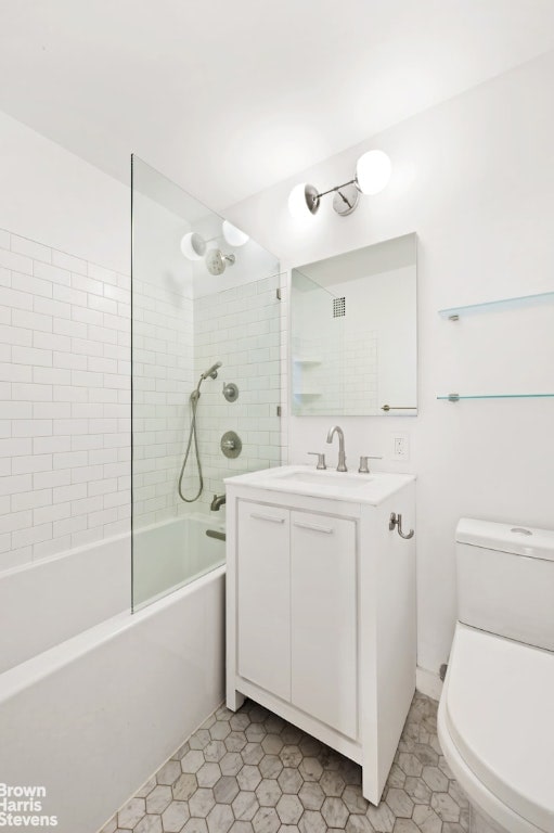 full bathroom featuring vanity, tiled shower / bath, tile patterned floors, and toilet