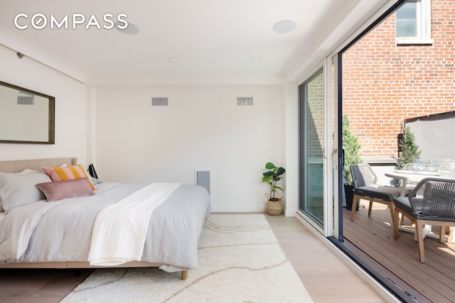 bedroom with light wood-type flooring, access to outside, visible vents, and baseboards