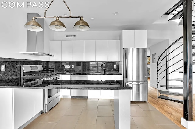 kitchen featuring sink, dark stone countertops, stainless steel appliances, tasteful backsplash, and white cabinets