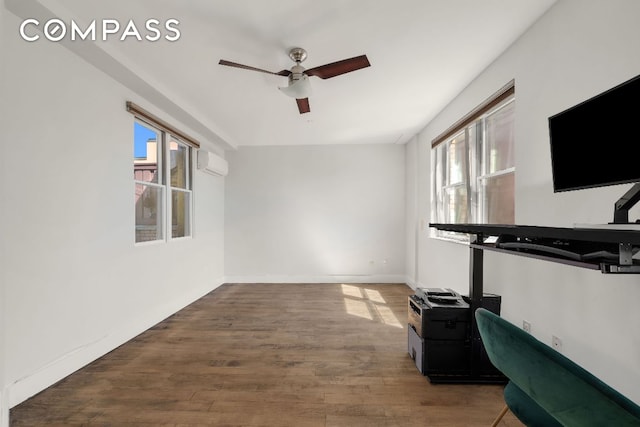 workout room featuring baseboards, a ceiling fan, wood finished floors, and a wall mounted air conditioner