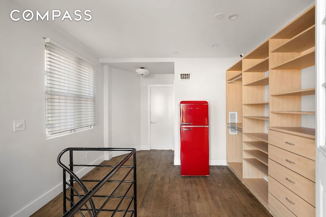 spacious closet with dark wood-style floors and visible vents