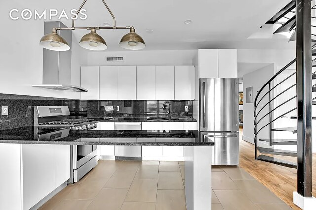 kitchen featuring visible vents, appliances with stainless steel finishes, white cabinets, dark stone countertops, and modern cabinets