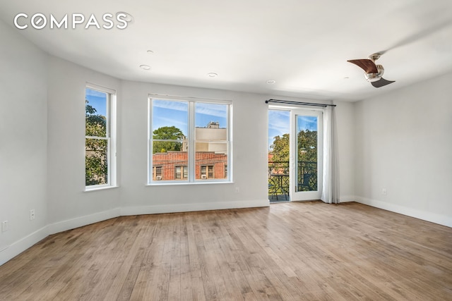 unfurnished room featuring wood finished floors, baseboards, and ceiling fan