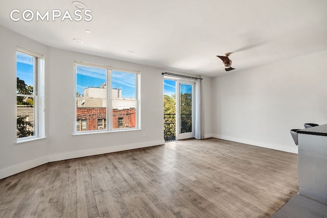 unfurnished living room with wood finished floors and baseboards