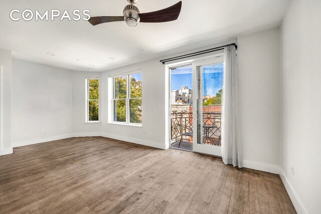 spare room with ceiling fan, baseboards, and wood finished floors