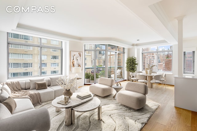 living room with crown molding, light wood-type flooring, and a wealth of natural light