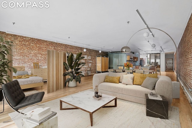 living room featuring brick wall and light hardwood / wood-style flooring