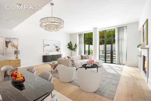 215 Sullivan St Unit Thc, New York City, NY 10012 - living room with wood finished floors, a chandelier, baseboards, and floor to ceiling windows