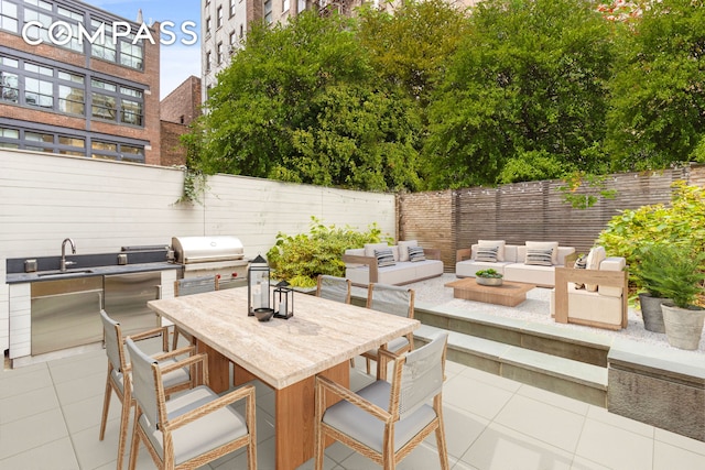 view of patio with a fenced backyard, grilling area, a sink, an outdoor hangout area, and exterior kitchen