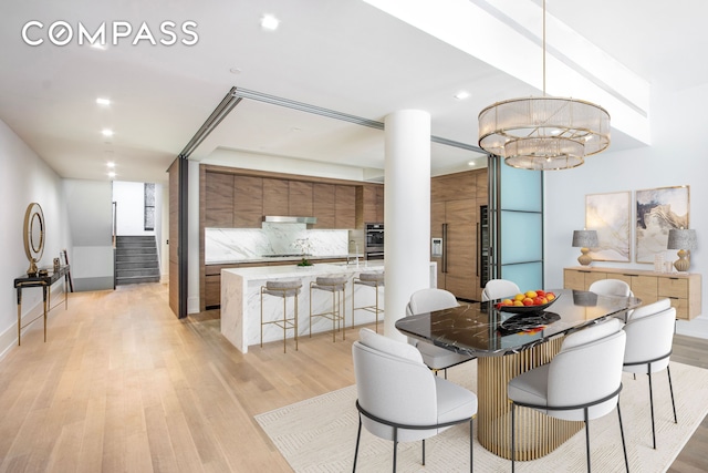 215 Sullivan St Unit Thc, New York City, NY 10012 - dining space with light wood-type flooring, stairway, recessed lighting, a chandelier, and baseboards