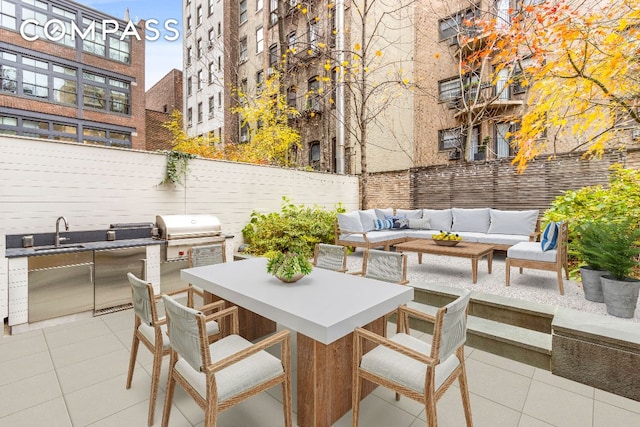 view of patio with area for grilling, sink, outdoor lounge area, and exterior kitchen