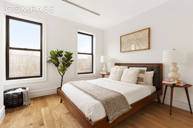 bedroom with baseboards and wood finished floors