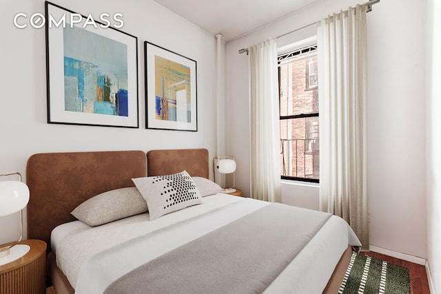 bedroom featuring baseboards and wood finished floors