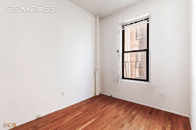 spare room featuring baseboards, a healthy amount of sunlight, and light wood-style flooring