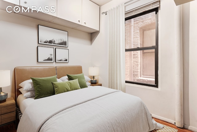 bedroom with wood finished floors and baseboards