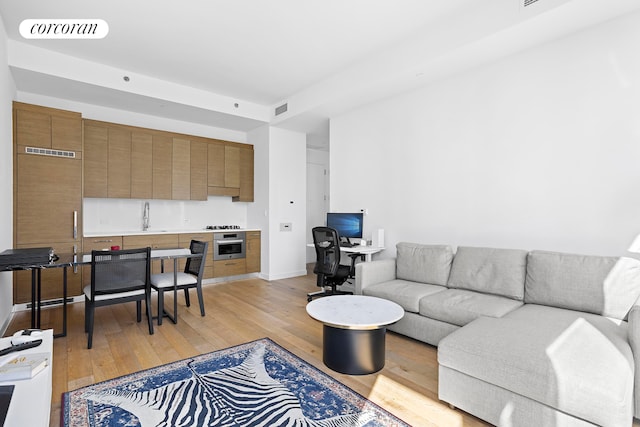 living room featuring baseboards, visible vents, and light wood-style floors