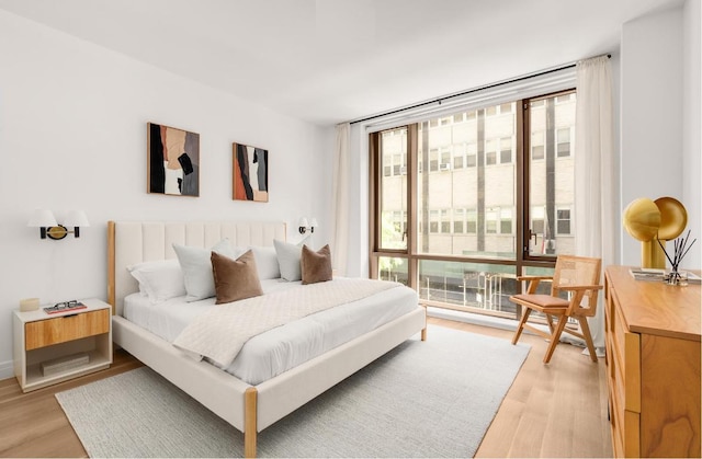 bedroom featuring light hardwood / wood-style floors and expansive windows