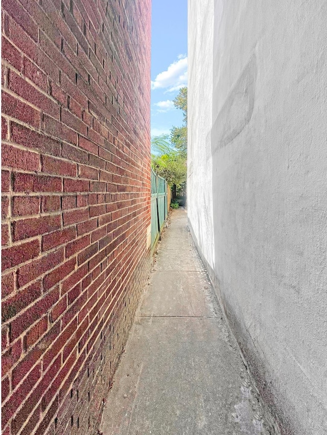 view of property exterior with brick siding and fence