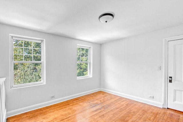 spare room with light wood-style flooring and baseboards