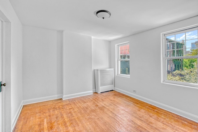 unfurnished room with light wood-type flooring and baseboards