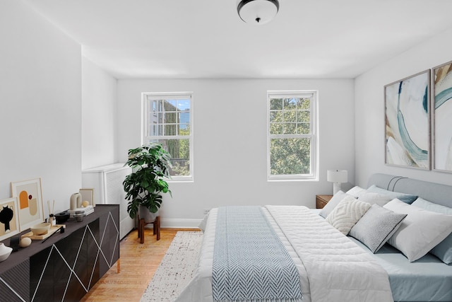 bedroom featuring light wood-style flooring, multiple windows, and baseboards