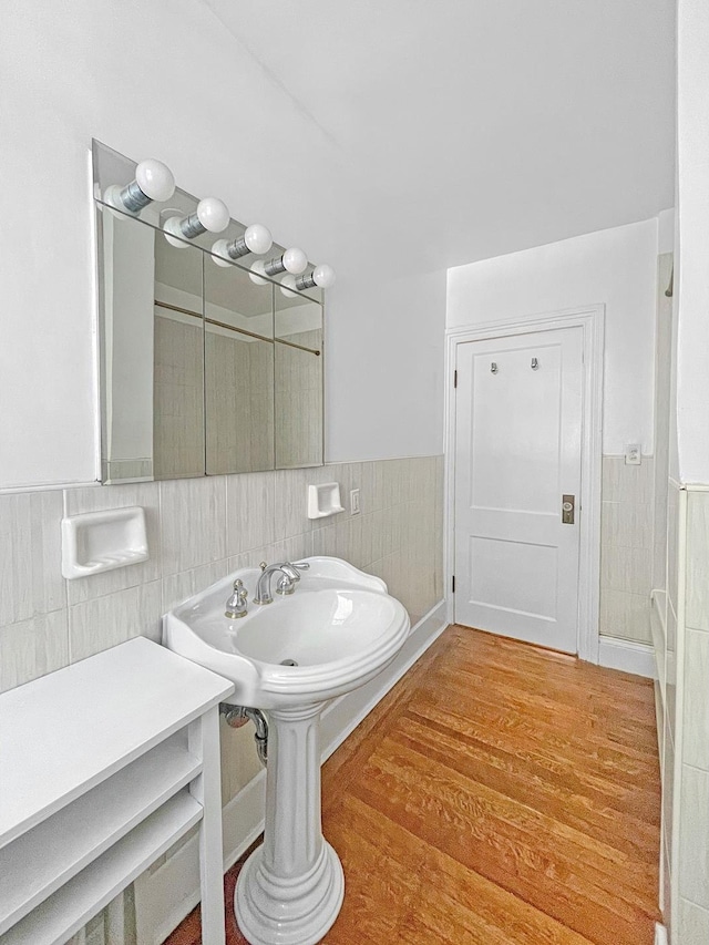 bathroom featuring wood finished floors, tile walls, and wainscoting