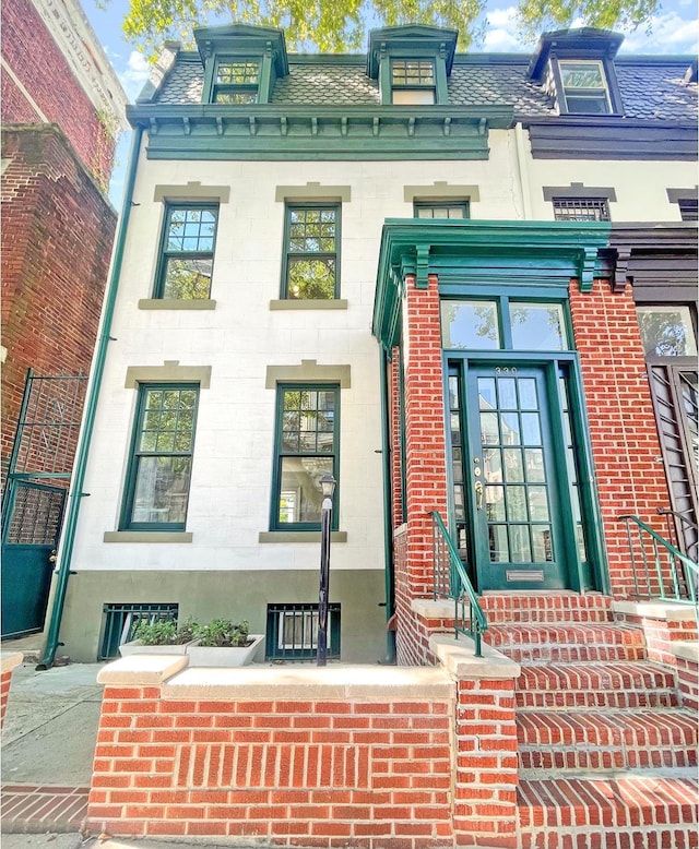 entrance to property with roof with shingles and mansard roof