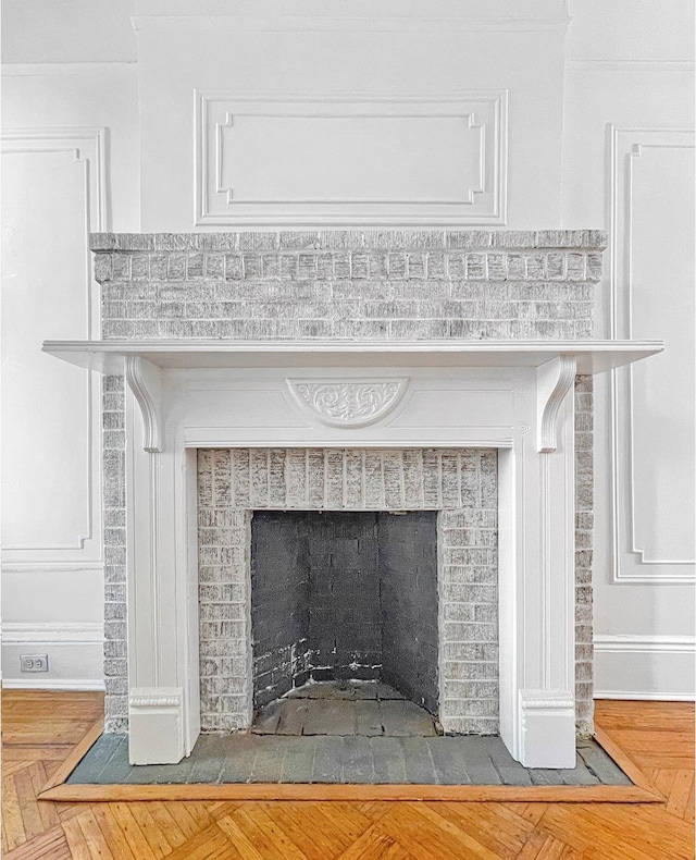 room details featuring a brick fireplace and baseboards