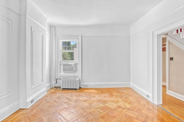 spare room featuring radiator, baseboards, and cooling unit