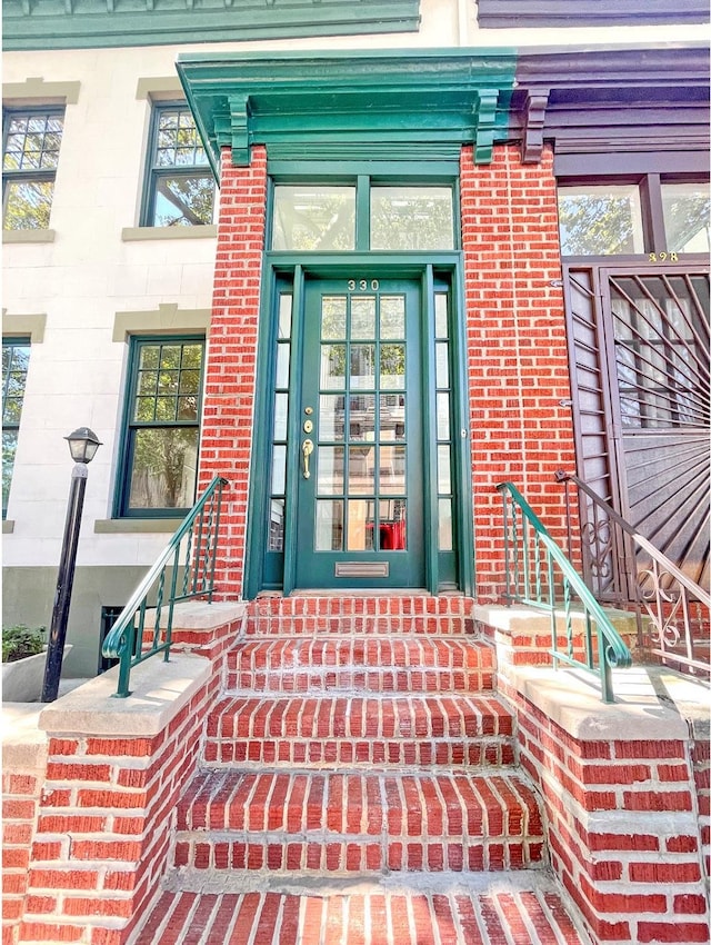 view of exterior entry featuring brick siding