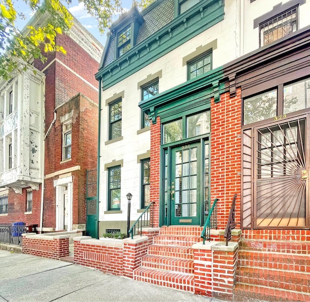 doorway to property featuring mansard roof and a high end roof