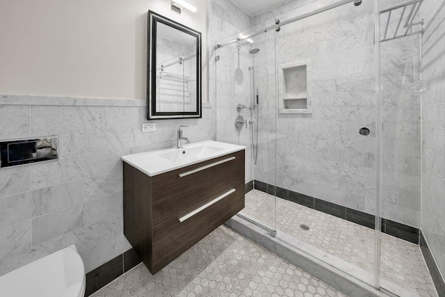 bathroom with tile walls, vanity, an enclosed shower, tile patterned floors, and toilet