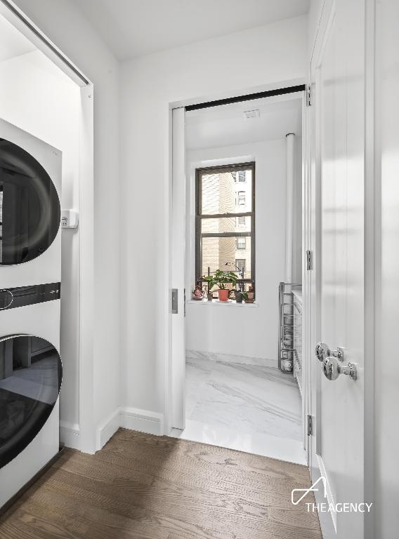 washroom featuring stacked washer and dryer and hardwood / wood-style floors