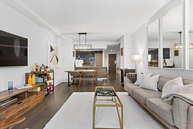 living room with dark hardwood / wood-style flooring and an inviting chandelier