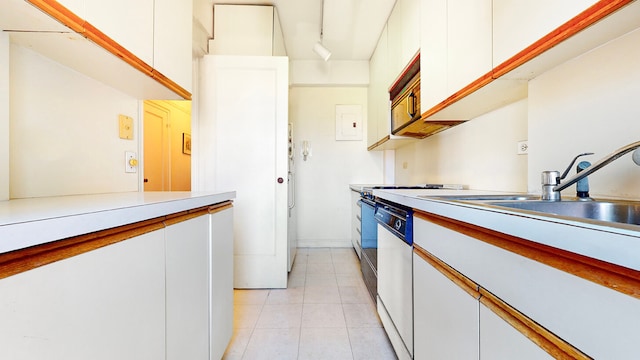 kitchen featuring light tile patterned flooring, track lighting, dishwasher, and white cabinets