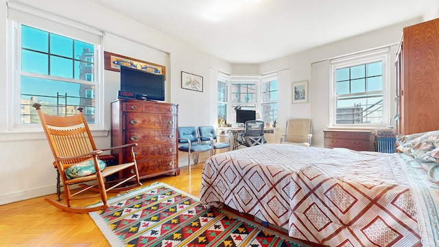 bedroom with multiple windows and parquet flooring