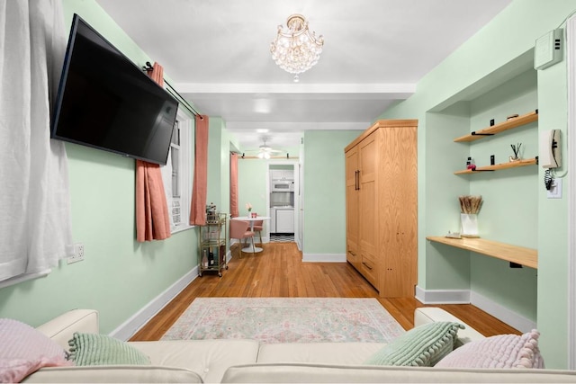 mudroom featuring light wood finished floors, an inviting chandelier, and baseboards