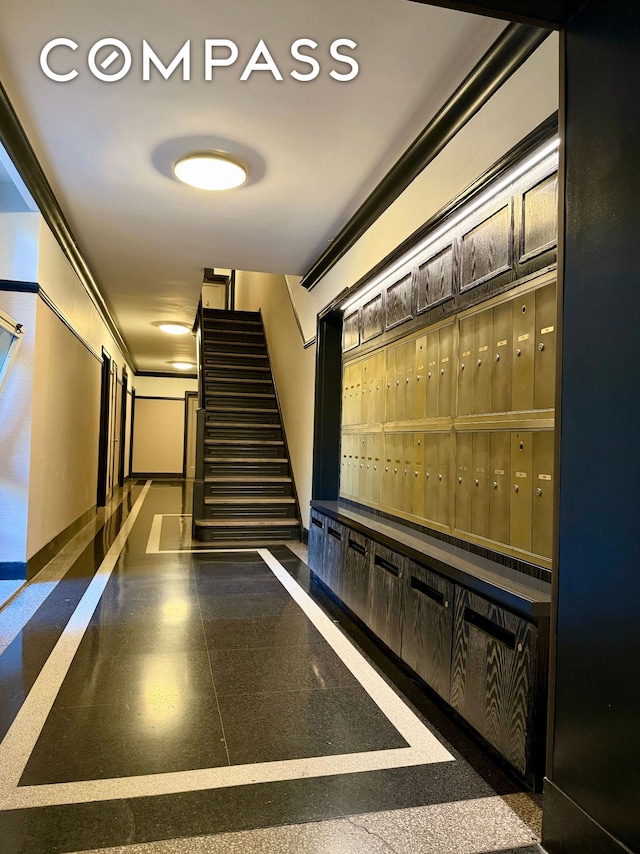 interior space featuring baseboards, granite finish floor, and mail area