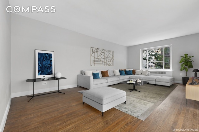 living room featuring radiator heating unit, baseboards, and wood finished floors