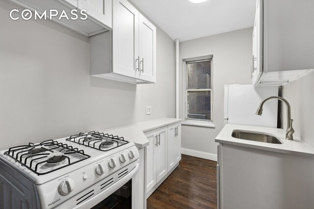 525 E 89th St Unit 2L, New York City, NY 10128 - kitchen featuring white gas stove, dark wood-style flooring, and white cabinets