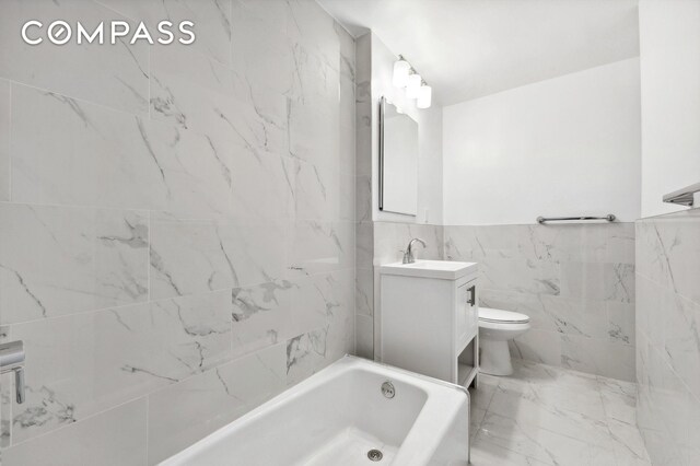 525 E 89th St Unit 2L, New York City, NY 10128 - full bathroom with vanity, tile walls, marble finish flooring, and a wainscoted wall