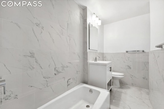 bathroom featuring tile walls, vanity, a tub, and toilet