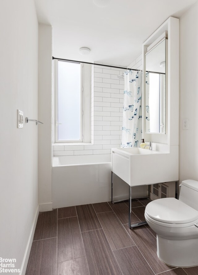 15 William St Unit 21A, New York City, NY 10004 - bathroom featuring toilet, shower / bath combination with curtain, and wood tiled floor
