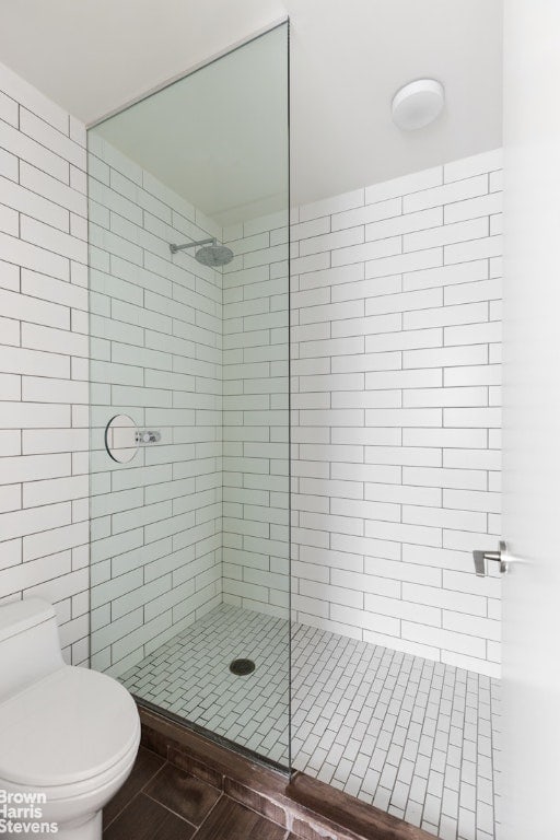 bathroom featuring toilet and tiled shower