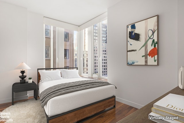 bedroom featuring dark wood-type flooring and expansive windows