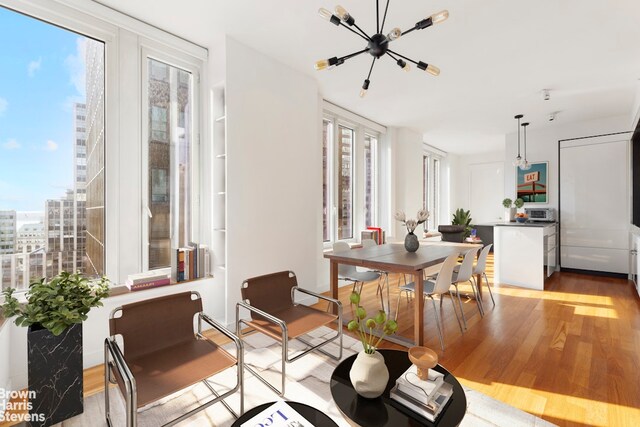 15 William St Unit 21A, New York City, NY 10004 - dining room featuring plenty of natural light, light wood finished floors, and a chandelier
