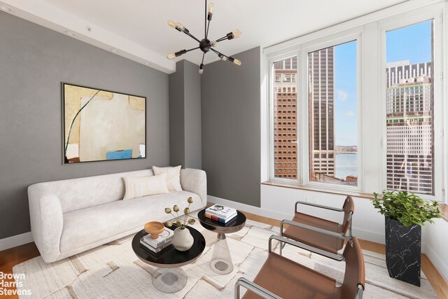 15 William St Unit 21A, New York City, NY 10004 - living room with baseboards, an inviting chandelier, and wood finished floors