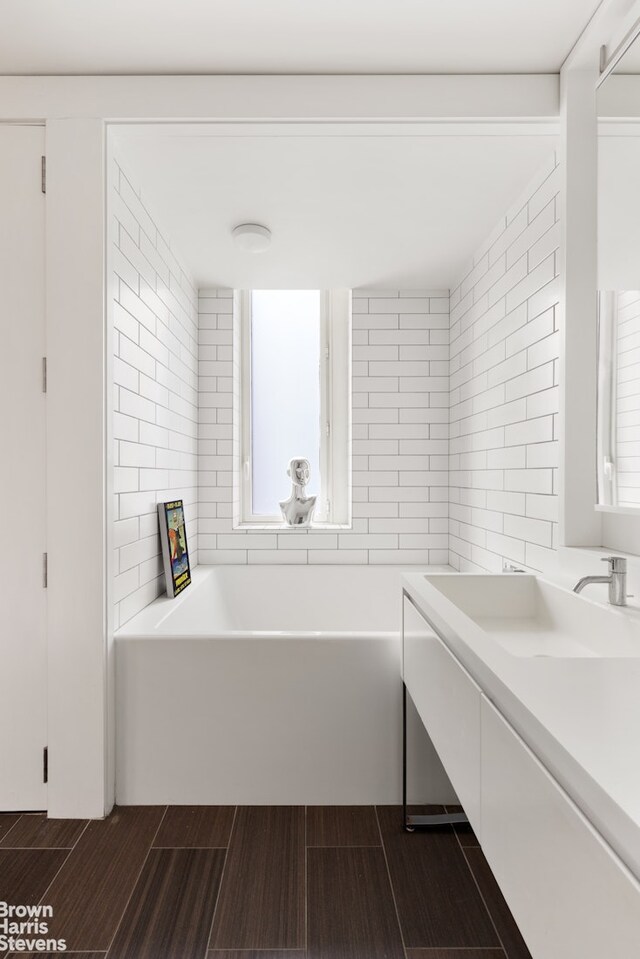 15 William St Unit 21A, New York City, NY 10004 - bathroom featuring vanity, a bathtub, and wood finished floors