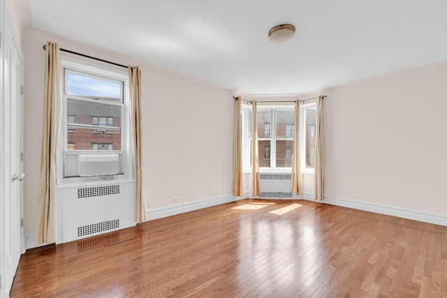 spare room with radiator heating unit and light hardwood / wood-style flooring